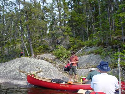 Timo and Al unloading canoe at Kenoshay to Dibble Lake portage while Don waits his turn. There is only unloading room for 1 canoe at a time. Believe me climbing up the rock behind is more difficult than it looks.